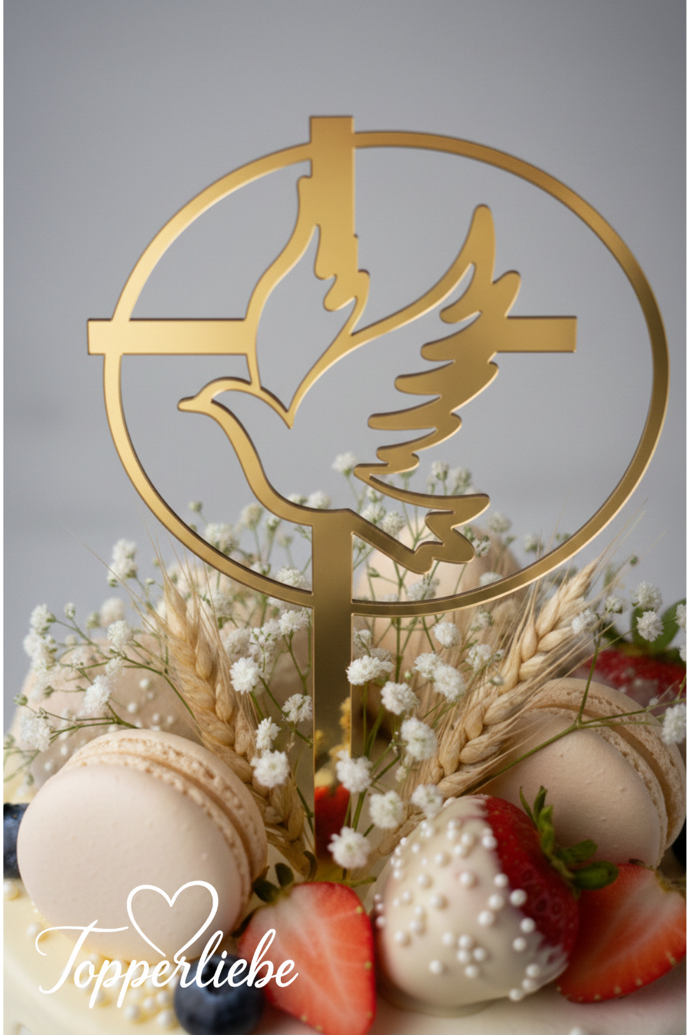 Kommunionstorte mit goldenem Torten-Topper – Motiv Taube im Kreis mit Kreuz, dekoriert mit ,Macarons und Schleierblumen.