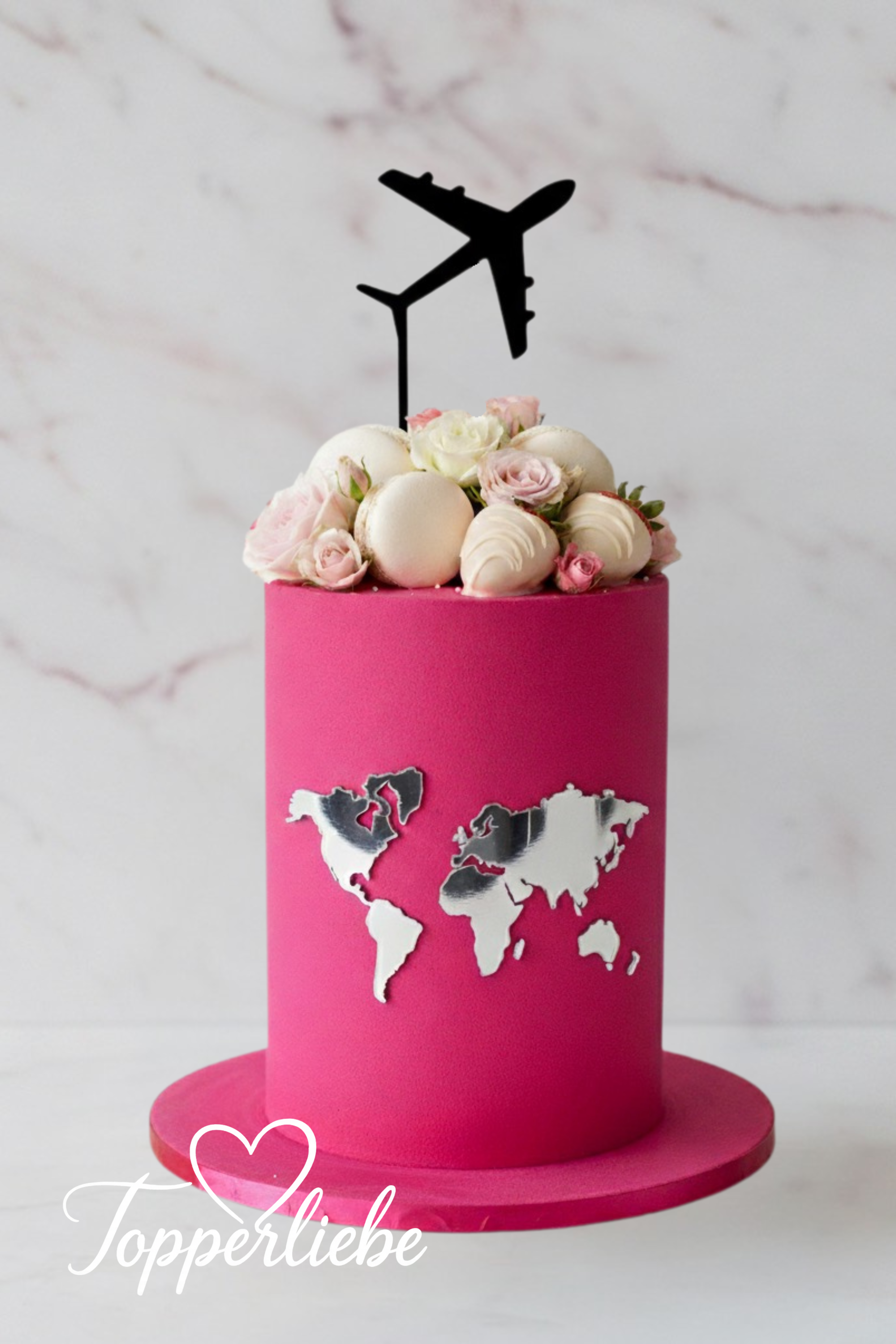 Rosa Kuchen mit silberner Weltkarte und schwarzem Flugzeug Torten Topper – moderne Reisedeko mit Blumen und Meringues, ideal für Weltenbummler