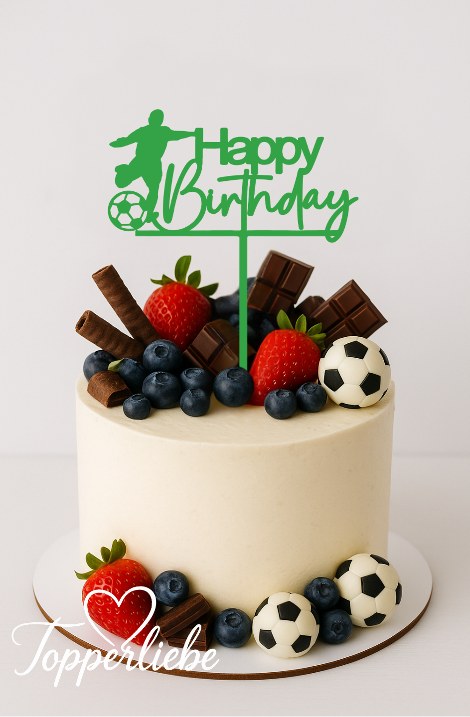 Moderner Tortentopper in Grün mit Fußballspieler und Schriftzug „Happy Birthday“ auf einer hellen Geburtstagstorte, dekoriert mit Beeren, Schokolade und kleinen Fußballdeko-Kugeln.