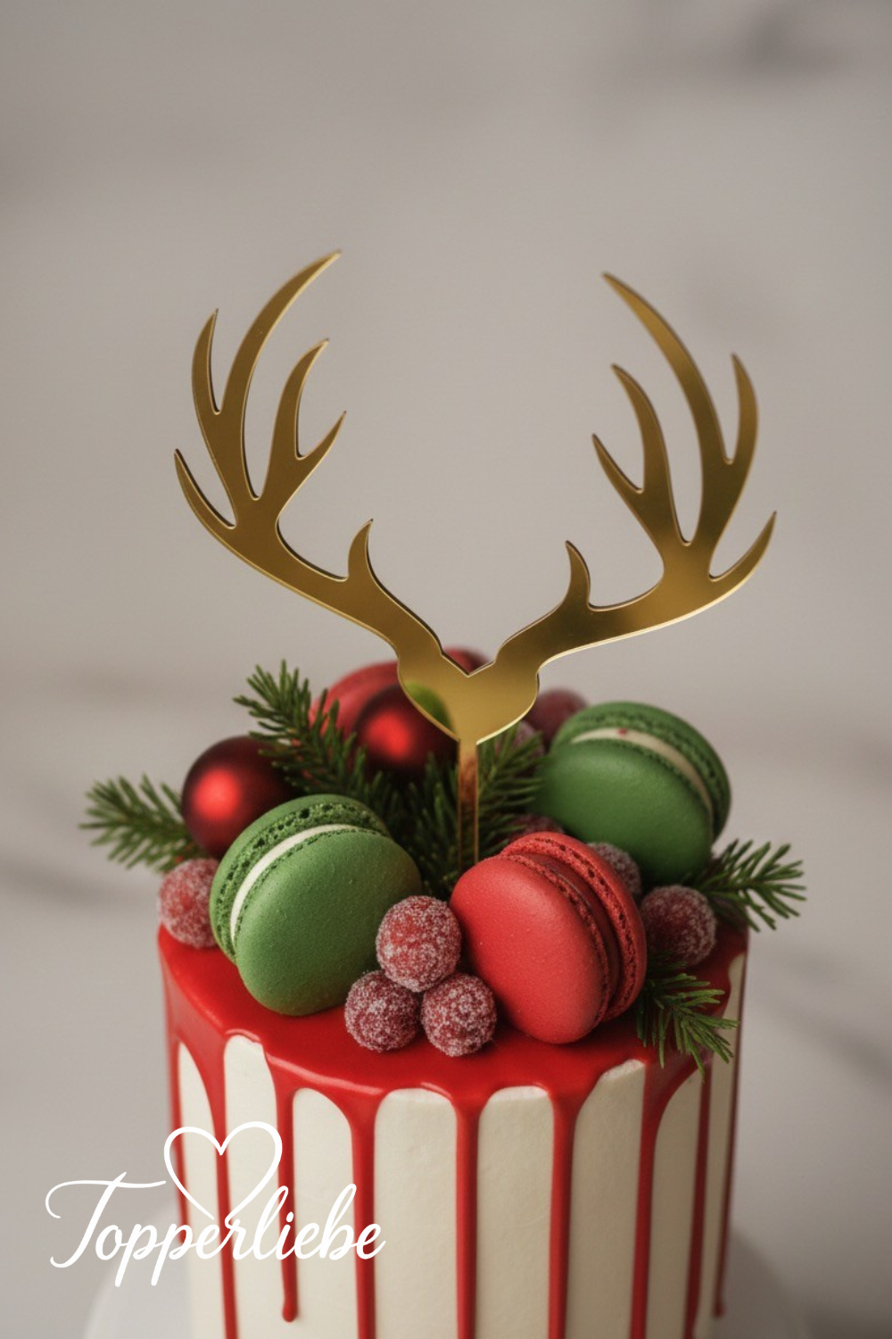 Detailansicht eines goldenen Rentier-Cake-Toppers auf einer festlichen Drip-Torte mit Makronen, im Topperliebe-Stil.