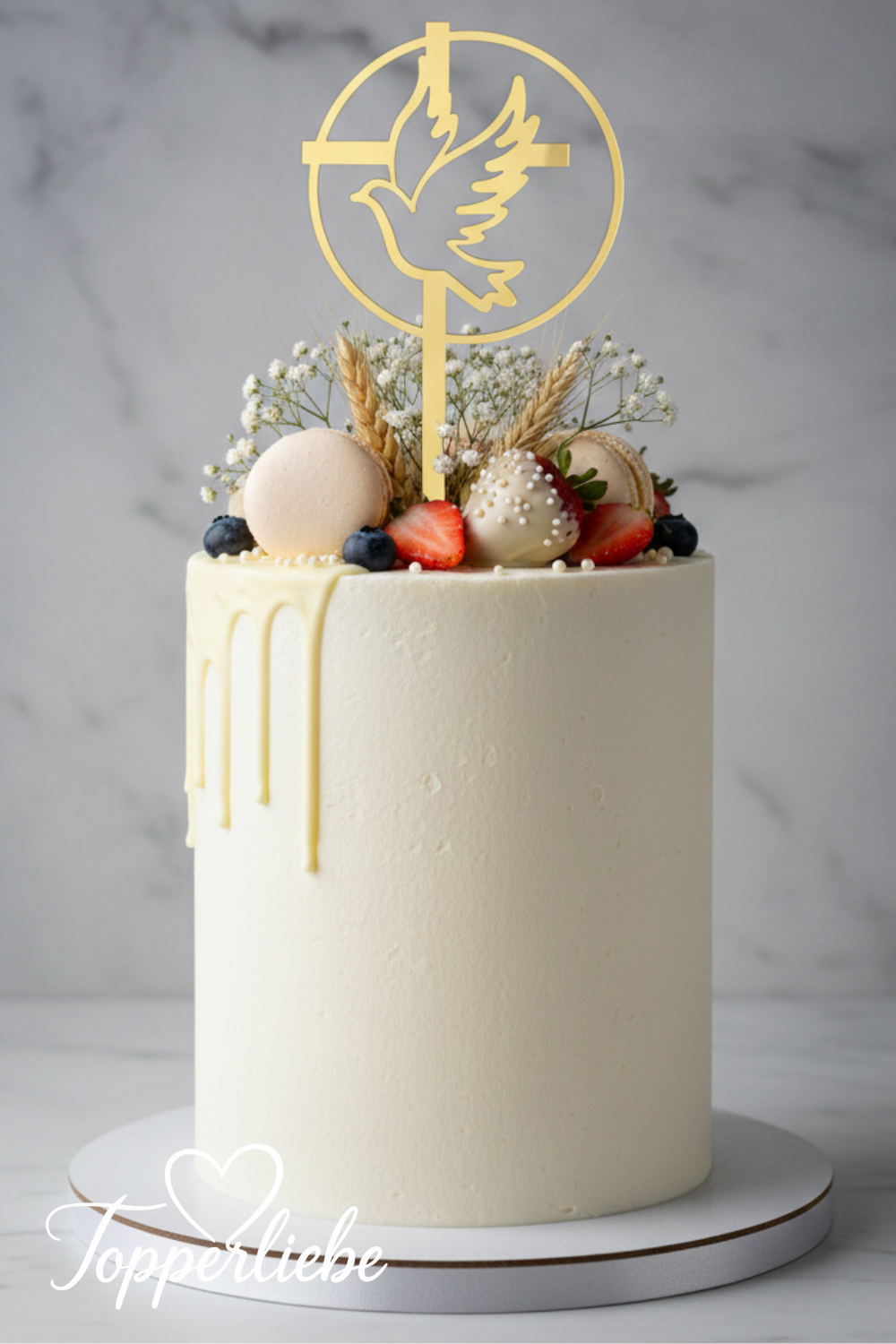 Elegante Kommunionstorte mit goldenem Torten-Topper – Motiv Taube im Kreis mit Kreuz, dekoriert mit Macarons und Schleierblumen.