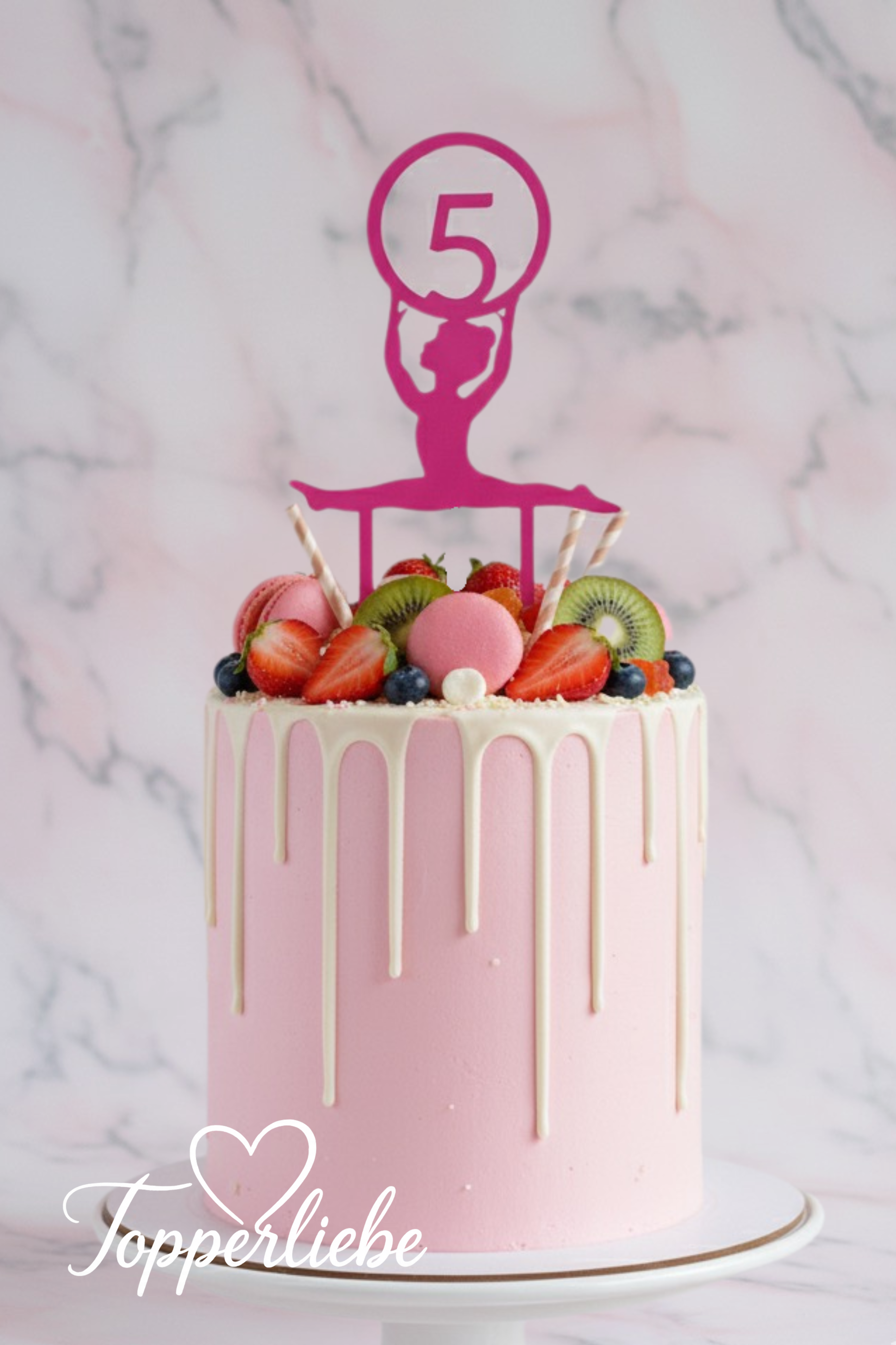 Rosa Kuchen mit weißem Drip und pinkem Akrobatin Torten Topper mit Hula-Hoop und Zahl im Kreis – dekoriert mit Beeren und Makronen, ideal für sportliche Geburtstage