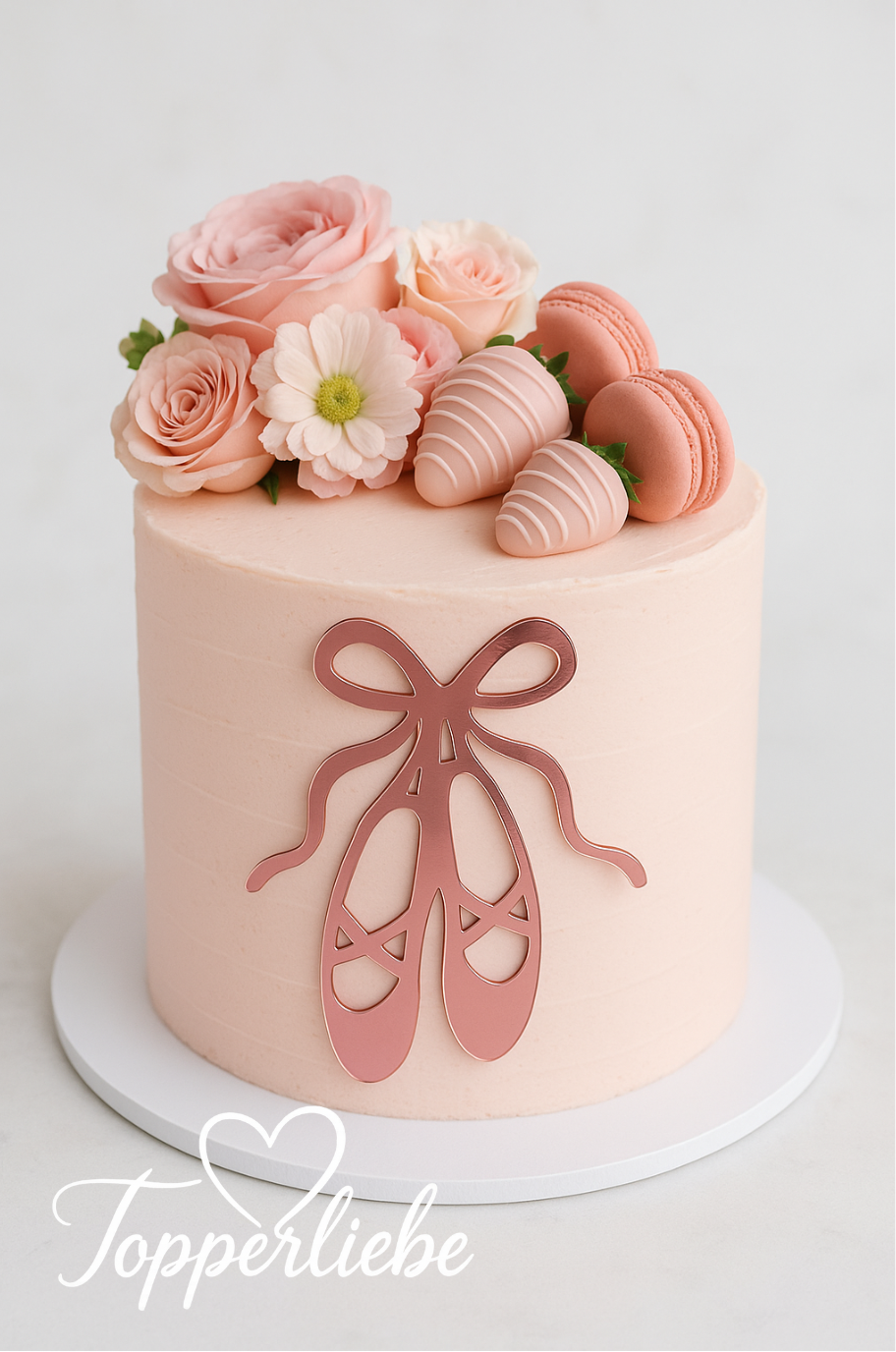 Tortendekoration in Form von Ballettschuhen aus Spiegelacryl in Rosa, an der Vorderseite einer rosa Torte mit Blumen und Macarons befestigt.