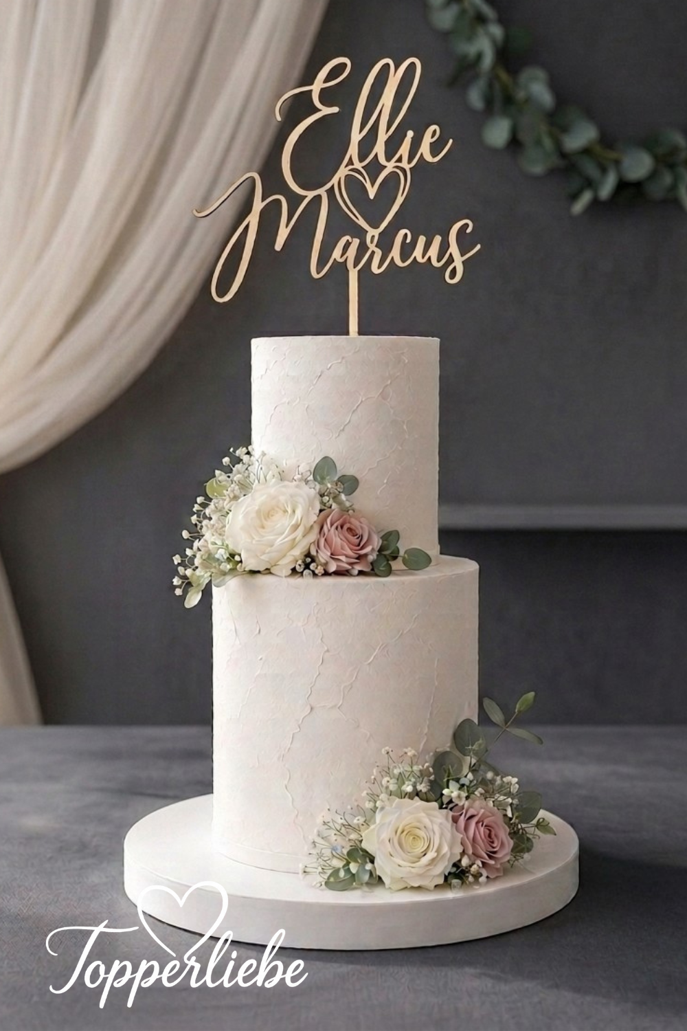 Personalisierter Cake Topper mit zwei Namen und Herz auf einer eleganten Hochzeitstorte.