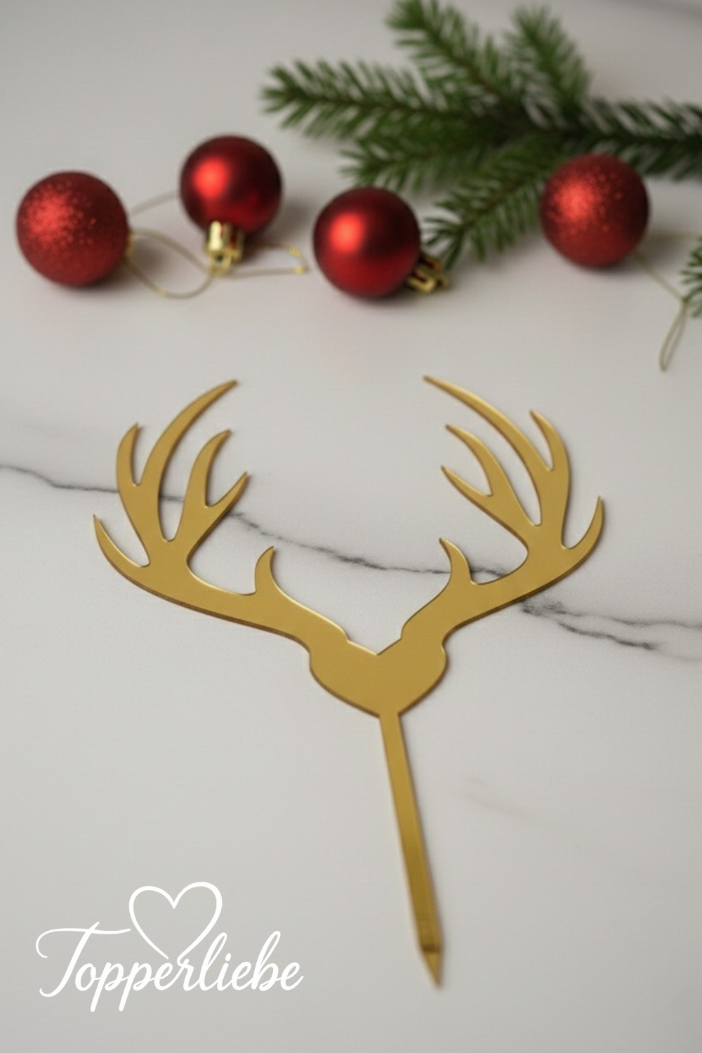 Goldener Rentier-Cake-Topper aus Acryl auf hellem Marmorhintergrund, im Topperliebe-Stil.
