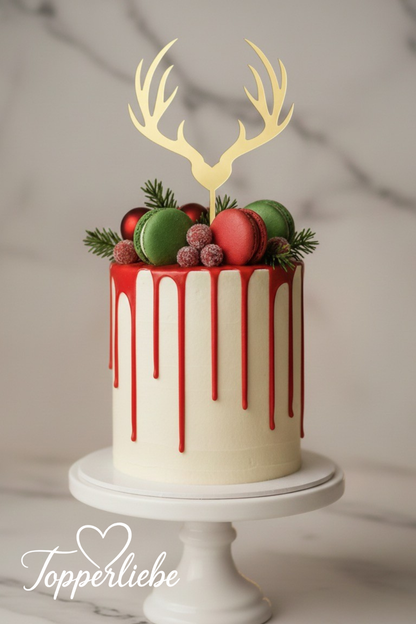 Goldener Rentier-Cake-Topper auf einer Weihnachts-Torte mit rotem Drip, Makronen und Festdeko im Topperliebe-Stil.