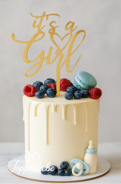 Heller Babyparty-Kuchen mit goldenem Acryl-Torten-Topper „It’s a Girl“, dekoriert mit Beeren, Macarons und hellen Baby-Accessoires – Produktfoto Topperliebe®.