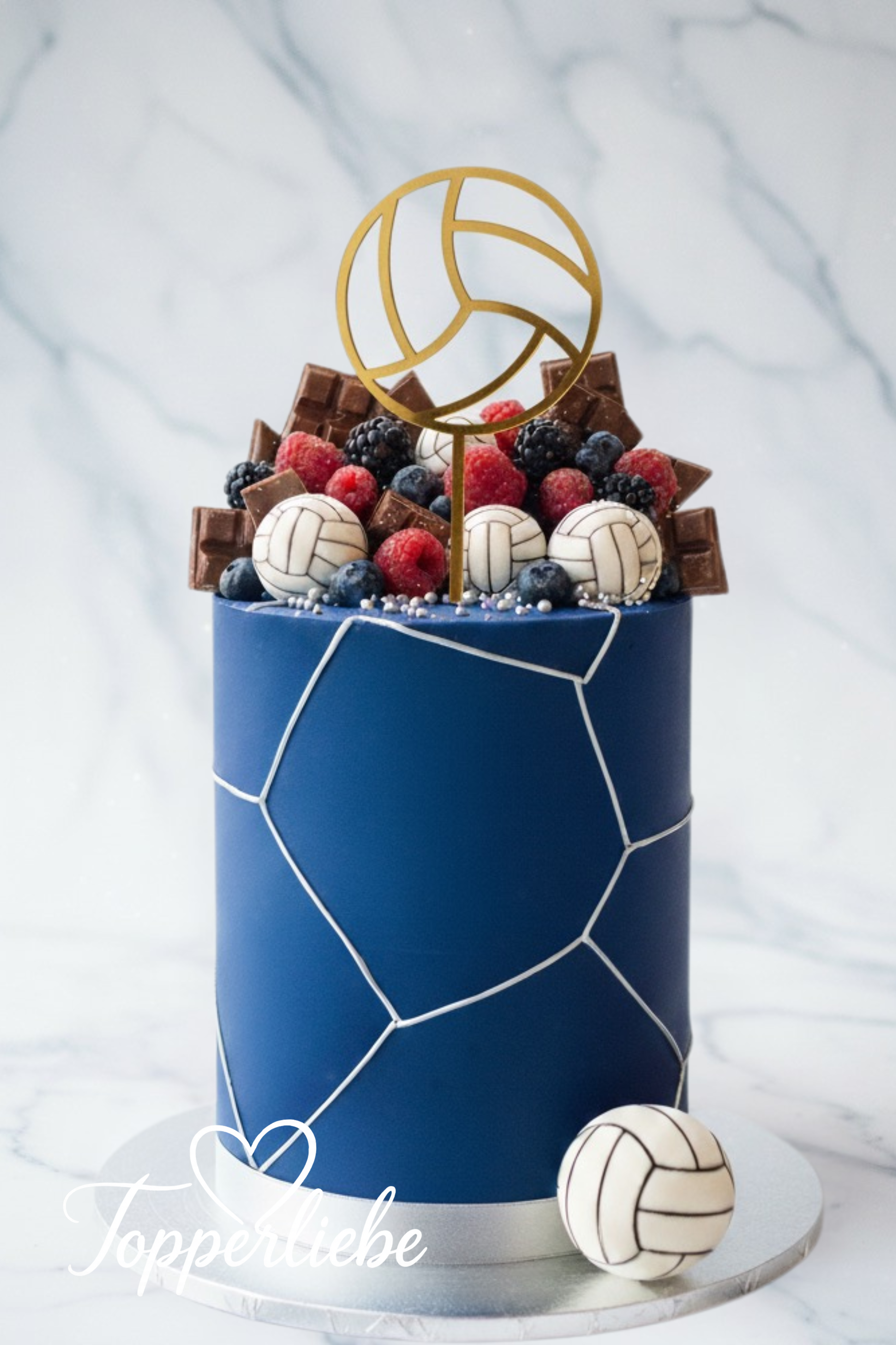 Volleyball Topper in Gold auf blauem Kuchen mit Beeren – sportliche Tortendeko von Topperliebe